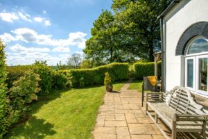 View of the Coach House garden - fully enclosed with beech hedge, lawn, terrace, hot tub and great views