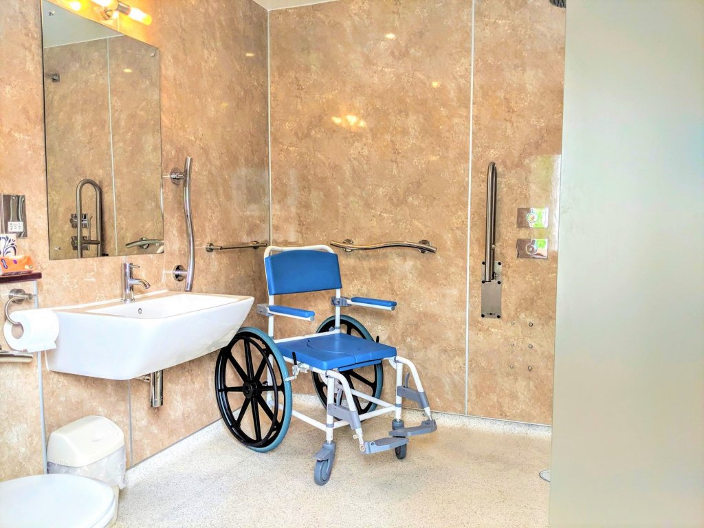 Accessible wetroom with self-propelled shower wheelchair