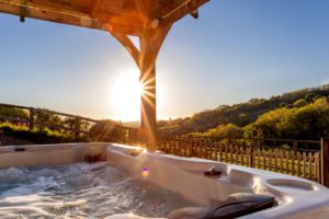 View down a wooded valley on a sunny evening from the private hot tub